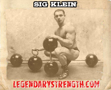 Sig Klein with an old-school dumbbell, kettlebell and barbell. 