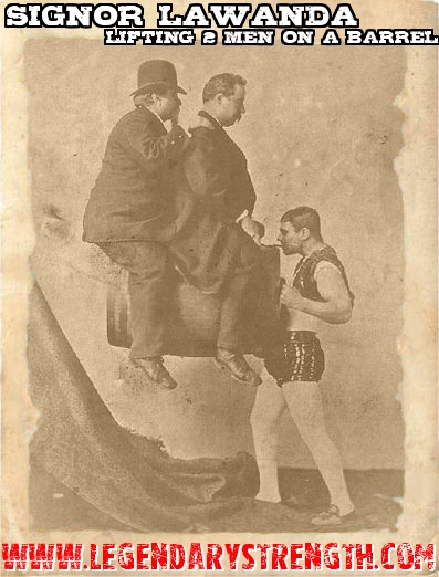 Sig Lawanda lifting two men on a barrel, partially using his jaw strength 